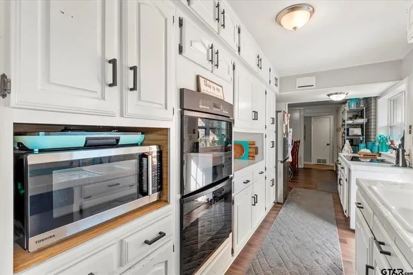 a kitchen with stainless steel appliances granite countertop white cabinets and white appliances
