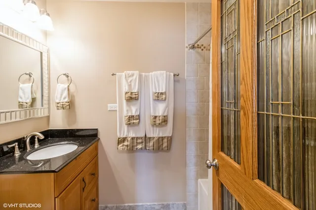 a bathroom with a granite countertop sink and a mirror