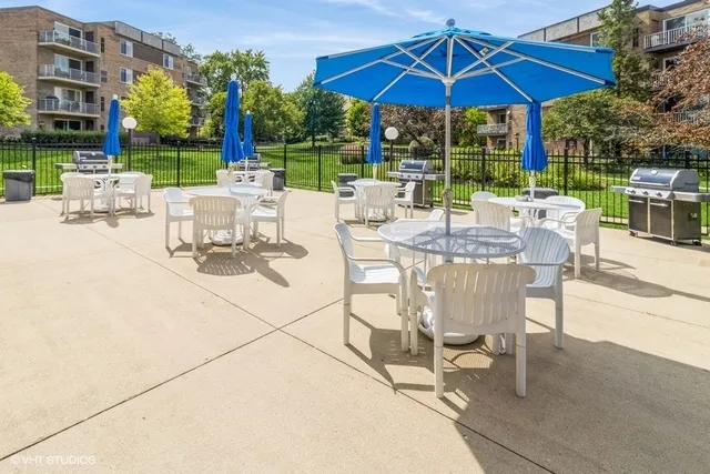 a view of a patio with a dining table and chairs under an umbrella