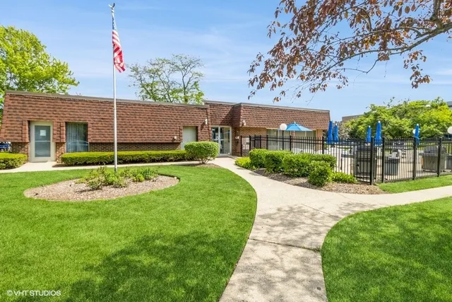 a view of a house with a yard and potted plants