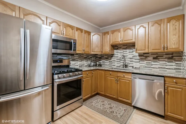 a kitchen with stainless steel appliances granite countertop a refrigerator stove microwave and sink