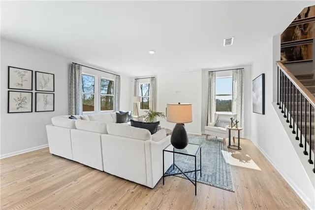 a living room with furniture and a wooden floor
