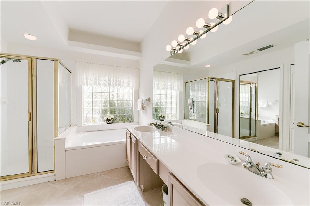 9156 Spring Run Boulevard Estero, FL 34135 - Photo 14 of 34 a bathroom with a large tub sink and double vanity