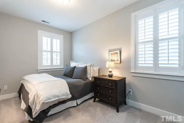 a bedroom with a bed and windows