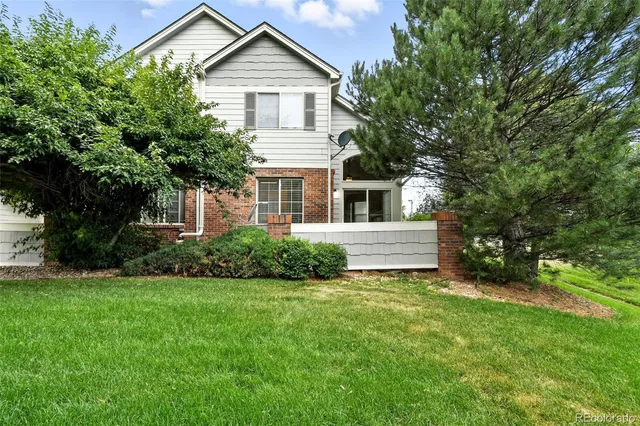 a view of a house with a yard and potted plants