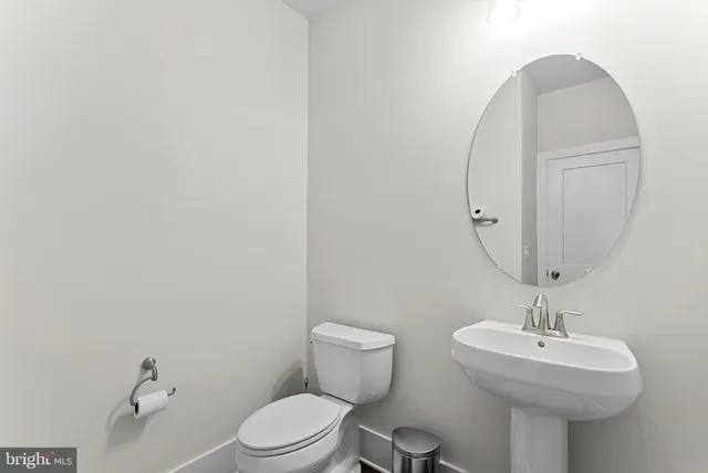 a bathroom with a sink a toilet and mirror
