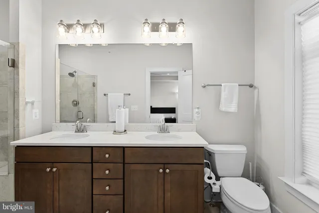 a bathroom with a sink vanity mirror and toilet