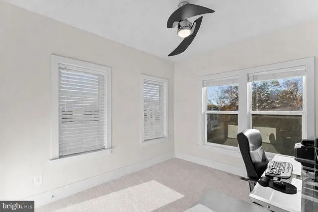 a view of a workspace with furniture and a window