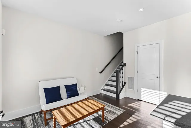 a view of a livingroom with wooden floor and white walls