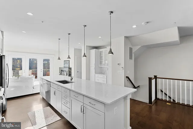 a kitchen with stainless steel appliances kitchen island granite countertop a sink and refrigerator