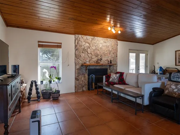 a living room with furniture a chandelier and a fireplace