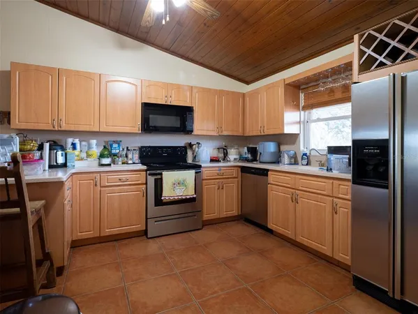 a kitchen with cabinets stainless steel appliances and a window