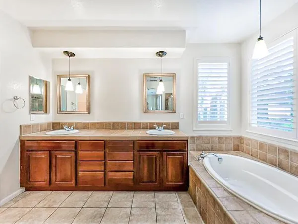 a bathroom with a tub sink and mirror