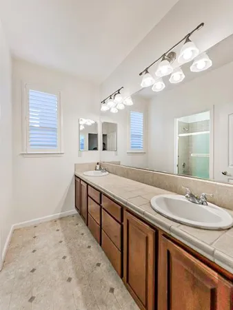 a spacious bathroom with a granite countertop sink and a mirror