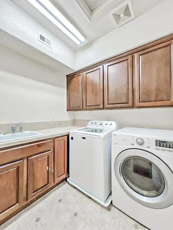 a utility room with sink dryer and washer