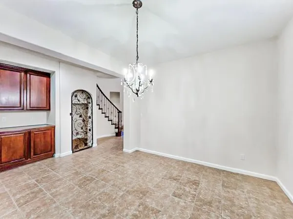a view of a livingroom with a chandelier fan and kitchen view