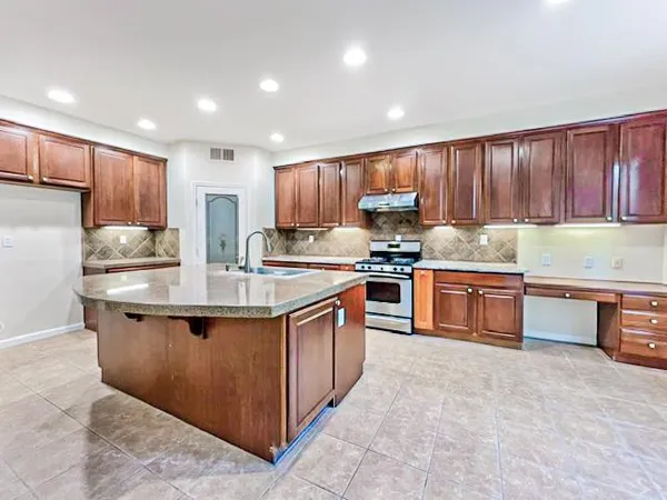 a kitchen with stainless steel appliances granite countertop a stove top oven a sink and dishwasher