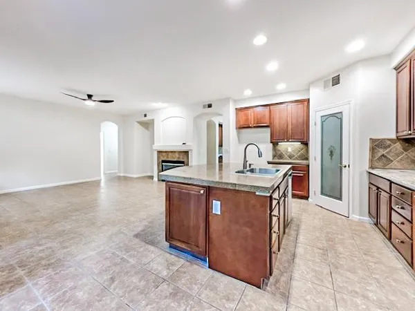 a kitchen with stainless steel appliances kitchen island granite countertop a stove refrigerator and a sink