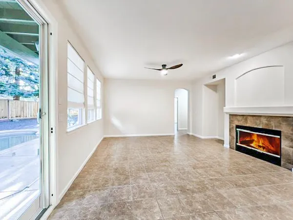 an empty room with windows and fireplace