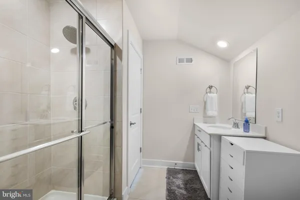 a bathroom with a double vanity sink a mirror and a shower
