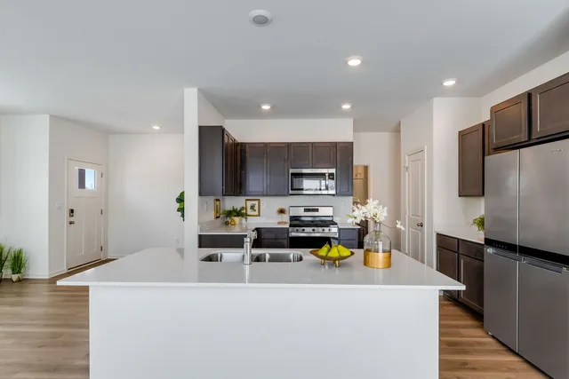 a view of kitchen with stainless steel appliances refrigerator stove microwave and sink