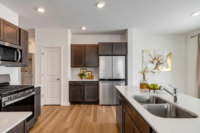 a kitchen with kitchen island granite countertop a sink a counter space stainless steel appliances and cabinets