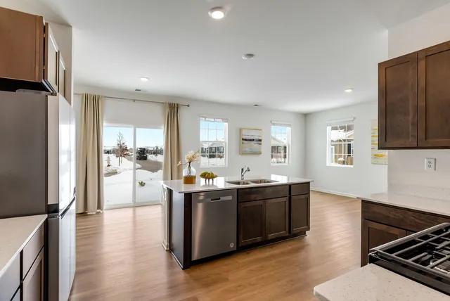 a view of kitchen with stainless steel appliances granite countertop a sink stove and refrigerator