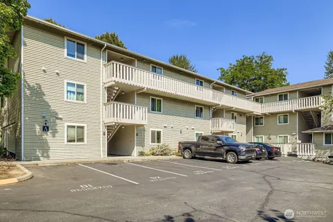 a front view of a building with cars parked