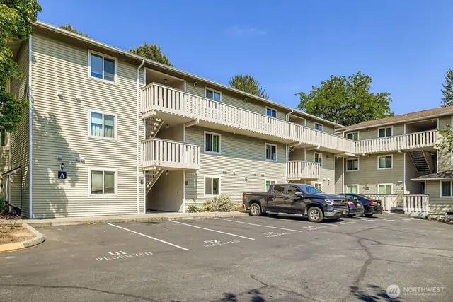 a front view of a building with cars parked