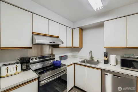 a kitchen with stainless steel appliances a sink dishwasher stove and cabinets