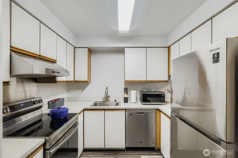 a kitchen with white cabinets and stainless steel appliances