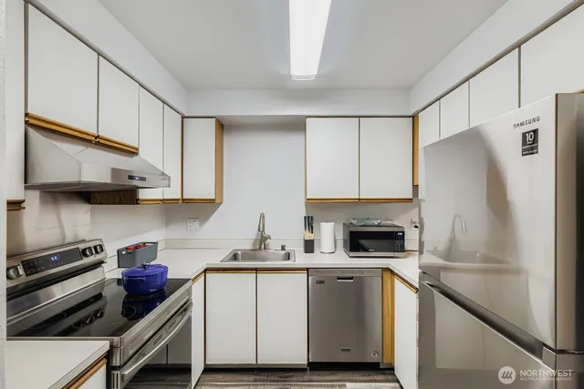 a kitchen with white cabinets and stainless steel appliances