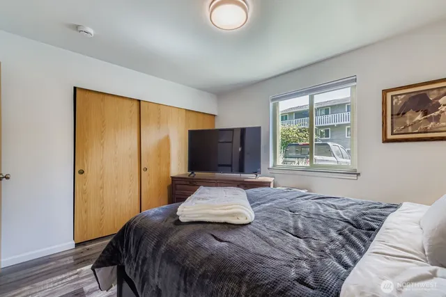 a bedroom with a bed and wooden floor