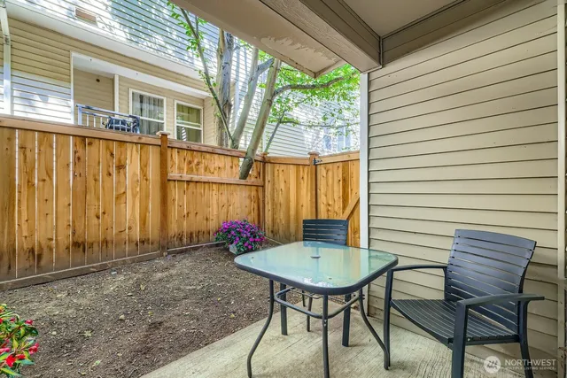 a view of a patio with a table and chairs and potted plants