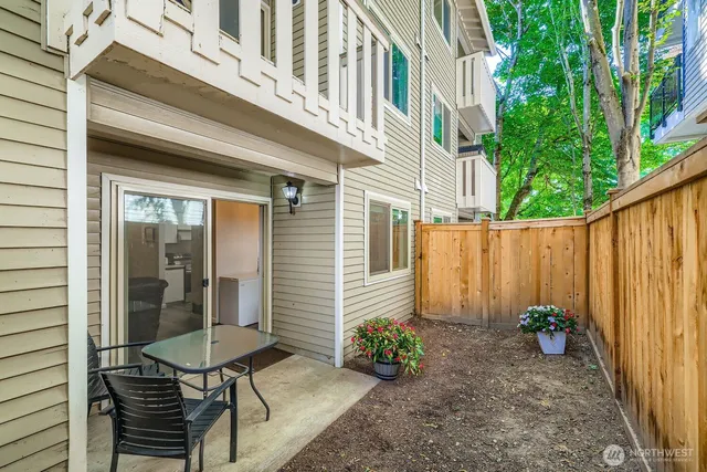 a view of a chair and table in backyard of the house