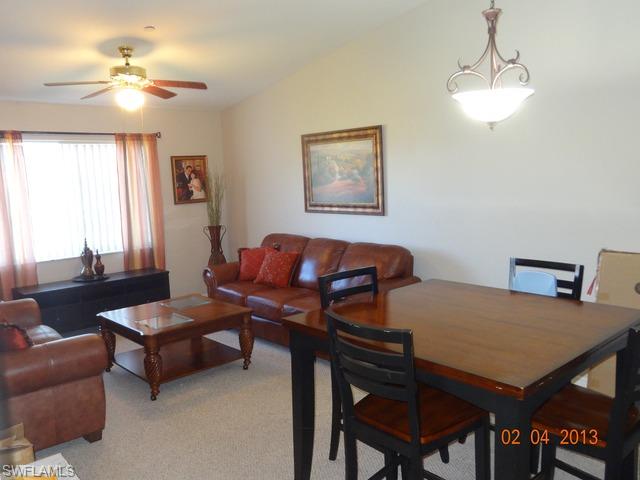 8284 Key Royal Circle, Unit 1332 Naples, FL 34119 - Photo 1 of 13 a living room with furniture a chandelier and a window