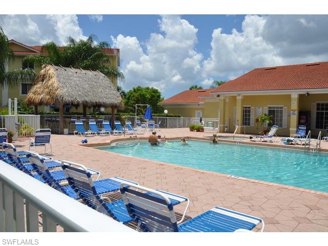 8284 Key Royal Circle, Unit 1332 Naples, FL 34119 - Photo 11 of 13 a swimming pool view with a seating space and a garden view