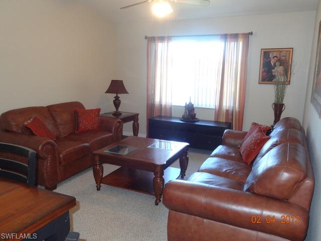 8284 Key Royal Circle, Unit 1332 Naples, FL 34119 - Photo 2 of 13 a living room with furniture and a window