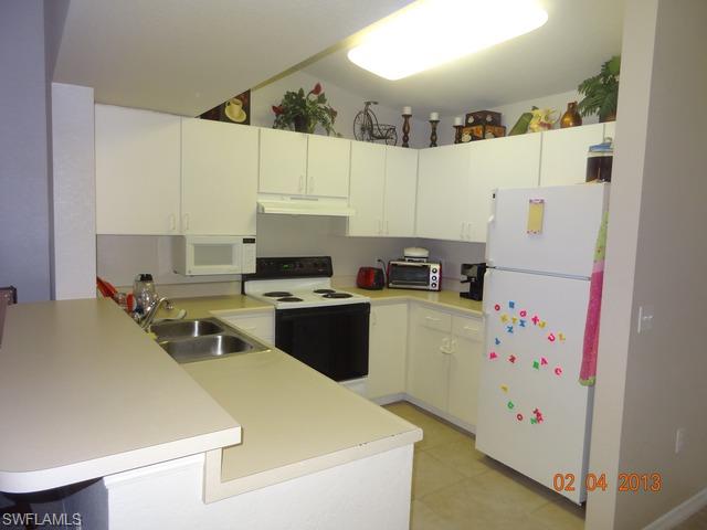 8284 Key Royal Circle, Unit 1332 Naples, FL 34119 - Photo 4 of 13 a room with a bed and a refrigerator