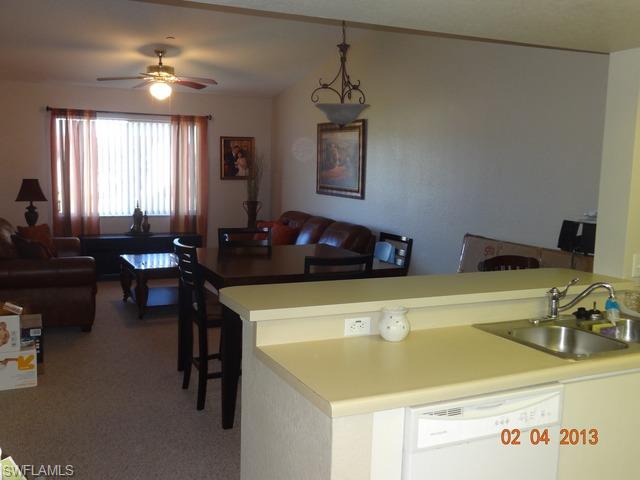 8284 Key Royal Circle, Unit 1332 Naples, FL 34119 - Photo 5 of 13 a kitchen with a table chairs and a refrigerator
