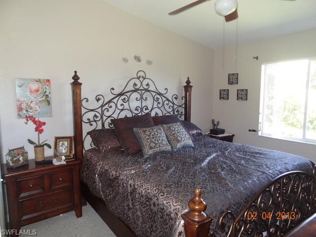 8284 Key Royal Circle, Unit 1332 Naples, FL 34119 - Photo 6 of 13 a large bed sitting in a bedroom next to a window