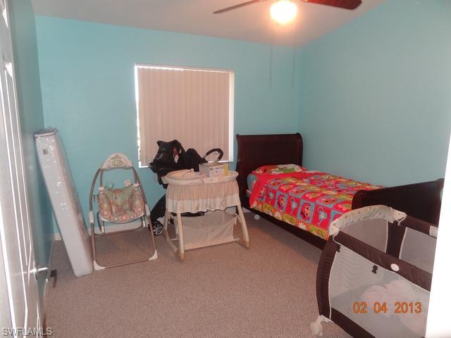 8284 Key Royal Circle, Unit 1332 Naples, FL 34119 - Photo 7 of 13 a bedroom with a bed a lamp and a dresser in it