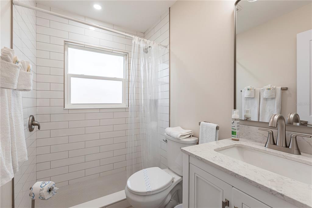 6020 Midnight Pass Road, Unit 15 Sarasota, FL 34242 - Photo 13 of 19 a bathroom with a sink a toilet and shower
