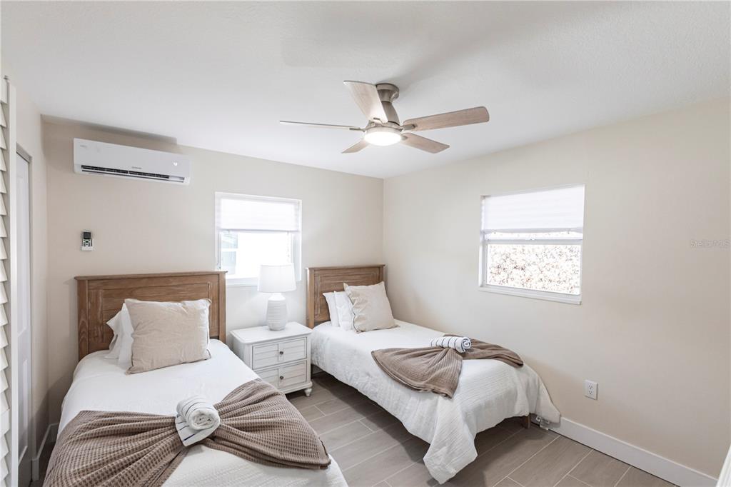 6020 Midnight Pass Road, Unit 15 Sarasota, FL 34242 - Photo 14 of 19 a bedroom with a bed and a chandelier