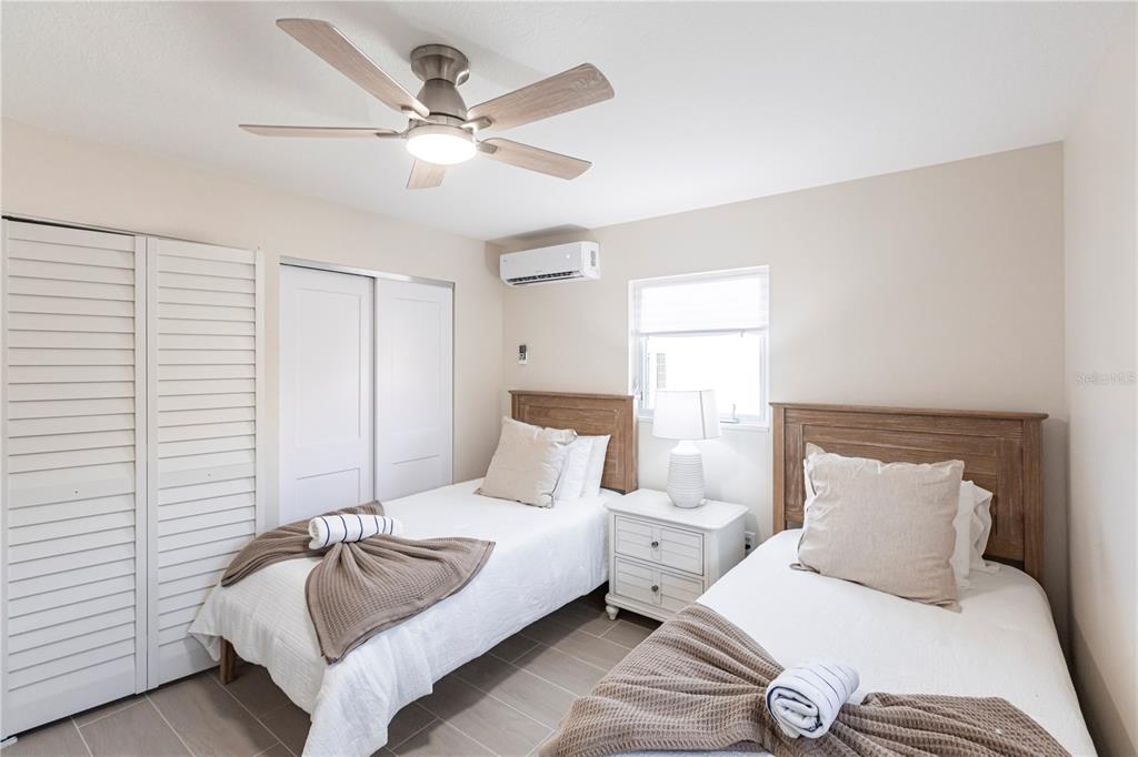 6020 Midnight Pass Road, Unit 15 Sarasota, FL 34242 - Photo 15 of 19 a bedroom with a bed and a chandelier