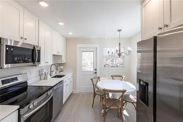 a kitchen with stainless steel appliances kitchen island granite countertop a sink refrigerator and cabinets