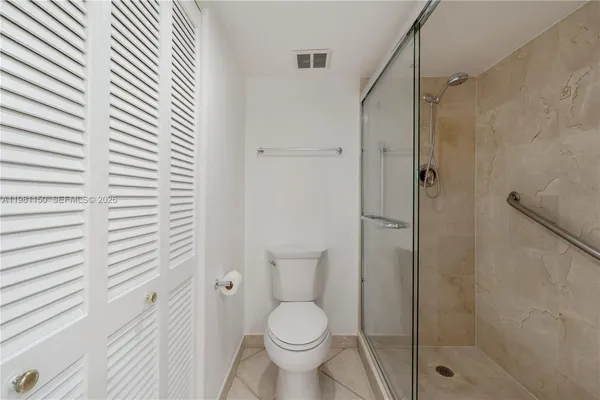 a bathroom with a toilet and a shower