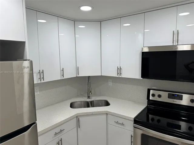 a kitchen with a sink and white cabinets