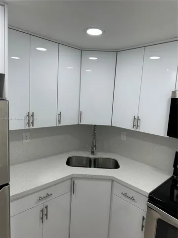 a kitchen with a sink cabinets and stainless steel appliances