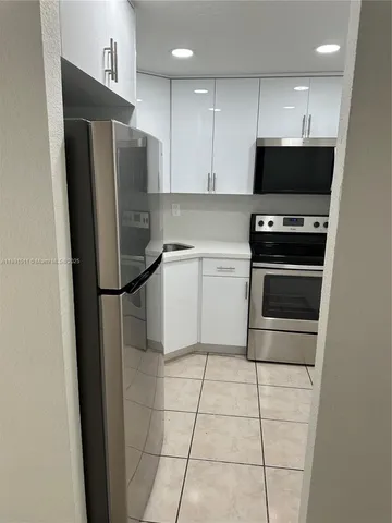 a kitchen with stainless steel appliances a refrigerator sink and microwave
